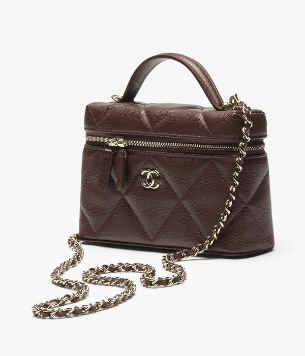 شنطة شانيل فانتي بوكس صغيرة باللون البني، مصنوعة من جلد طبيعي لامع مع سلسلة معدنية ذهبية، تجمع بين الشكل الصندوقي الأنيق والفخامة الكلاسيكية.