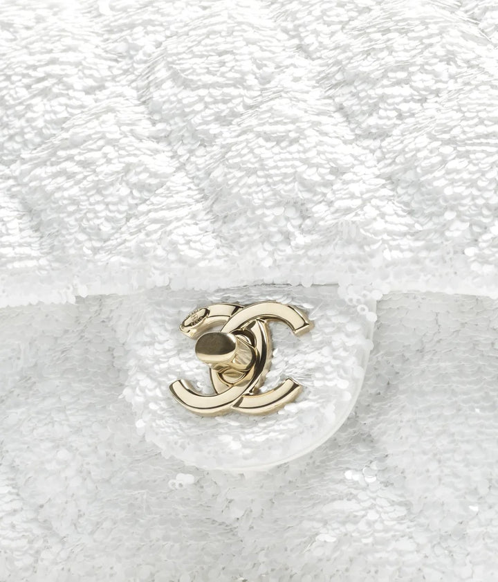 شنطة ماركة شانيل فلاب مطرزة بالترتر تظهر الشعار المعدني الذهبي