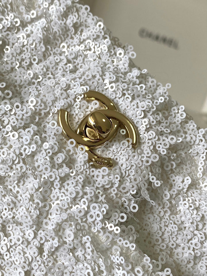 شنطة ماركة شانيل فلاب مطرزة بالترتر تظهر الشعار المعدني الذهبي بتصميم متقن يعكس التميز والاناقة الباريسية.