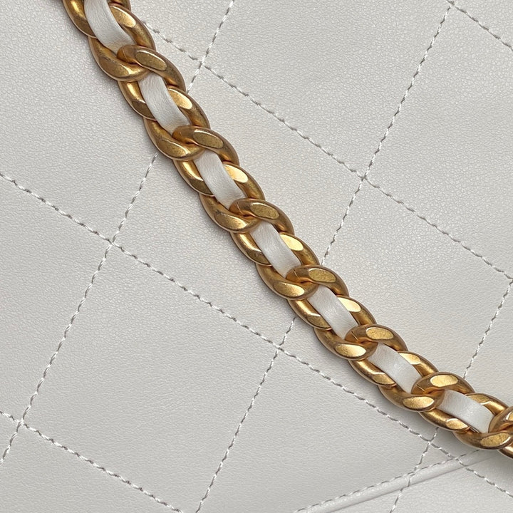 شنطة ماركة شانيل ماكسي فلاب باللون الابيض تظهر تفاصيل السلسلة المعدنية التي تضيف لمسة ترف على التصميم الكلاسيكي.