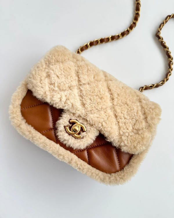 شنطة ماركة شانيل ميديم فلاب باللون البني مصنوعة من خامة شيرلينغ ناعمة وجلد حمل طبيعي مع اكسسوارات ذهبية تضيف لمسة فخامة واناقة كلاسيكية.