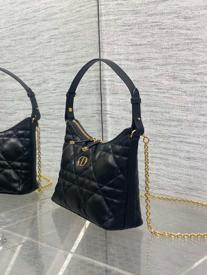 شنطة ميني ديور سوداء بتصميم ماكروكاناج أنيق، موضوعة بجانب الإكسسوارات لإبراز التفاصيل الفاخرة والتصميم المميز من ديور.