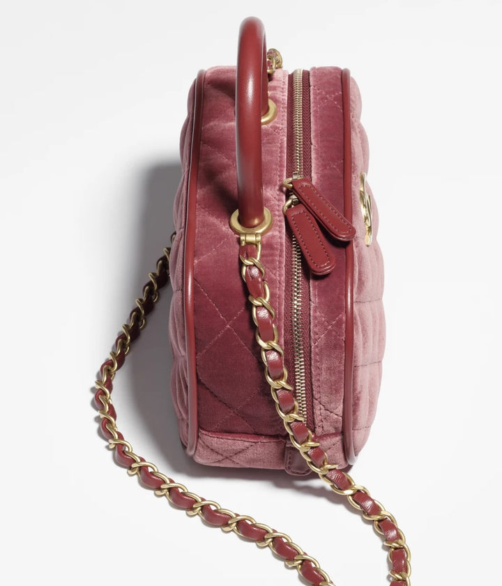 شنطة شانيل ميني بولينج خمري تظهر بزاوية جانبية توضح الدمج بين خامة الفيلفت الناعمة والجلد الطبيعي بتصميم انيق يناسب المناسبات الخاصة.